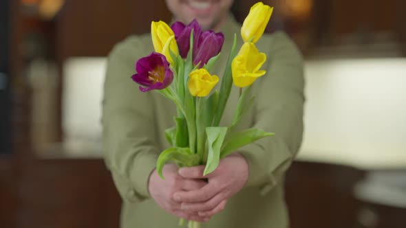 Live Camera Follows Bouquet of Flowers As Blurred Man Stretching Tulips Smiling Standing Indoors alt