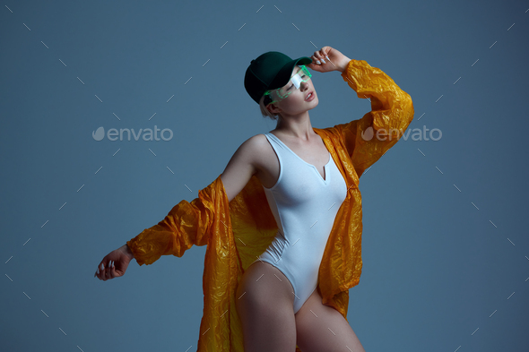 Futuristic woman in raincoat, cap and glasses - Stock Photo - Images