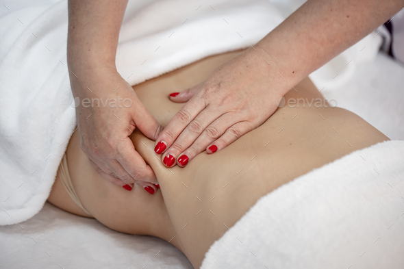 Female hands do a back massage to a man in the salon. Stock Photo by puhimec