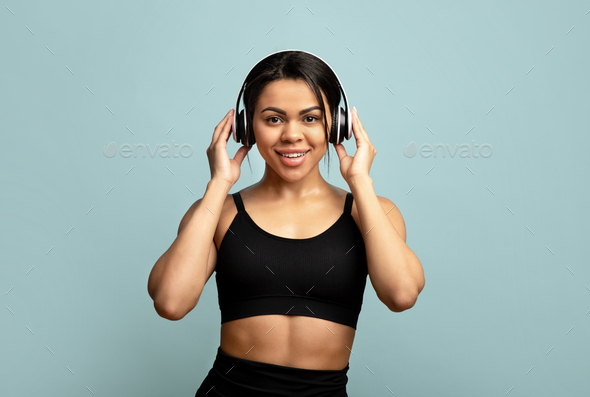 Workout with music, active free time during self-isolation from covid-19. Positive black lady with