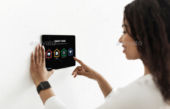 Black lady using smart home device, pushing button on pad