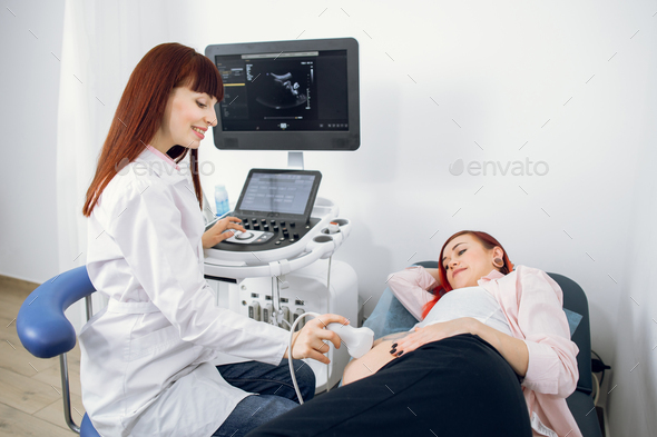 Female happy smiling doctor performs ultrasound examination of her female patient for regular