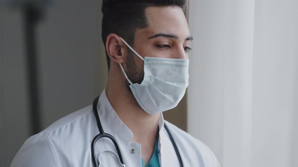 Male Pensive Thoughtful Arab Man Therapist Surgeon Wear White Uniform Medical Face Mask Standing at alt
