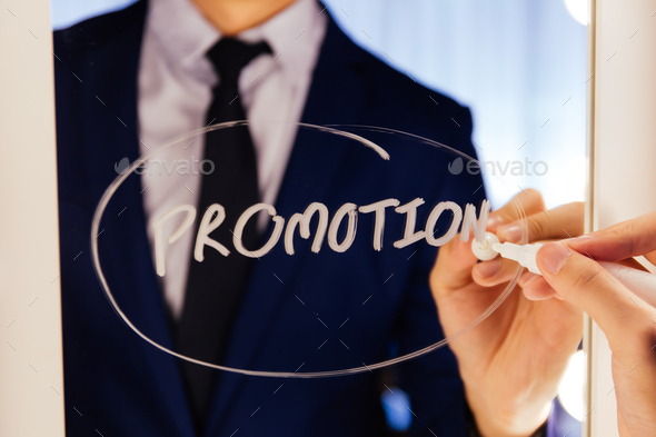 Smart business man writing the word Promotion on the mirror board - Promotion business word letter.