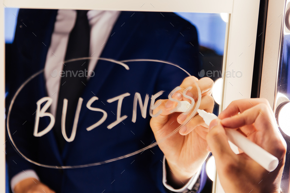 Smart business man writing the word Business on the mirror board - Business text