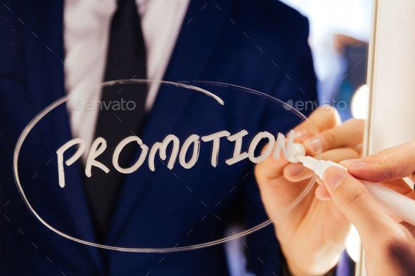 Smart business man writing the word Promotion on the mirror board - Promotion business word letter.