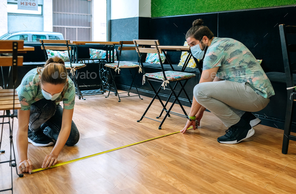 Workers measuring social distance on the floor