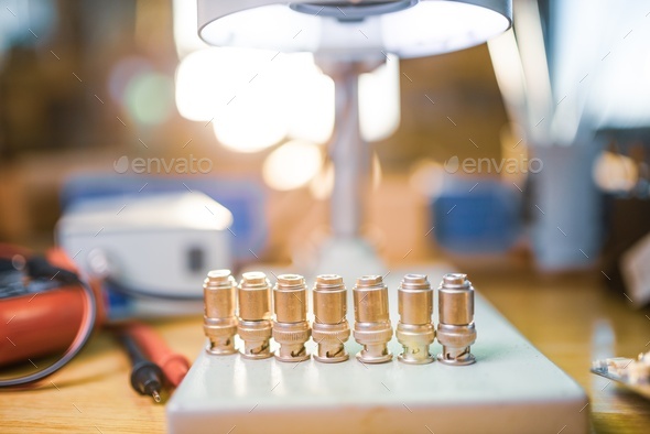 Modern microscope, connectors component and large green microcircuit in workshop laboratory - Stock Photo - Images