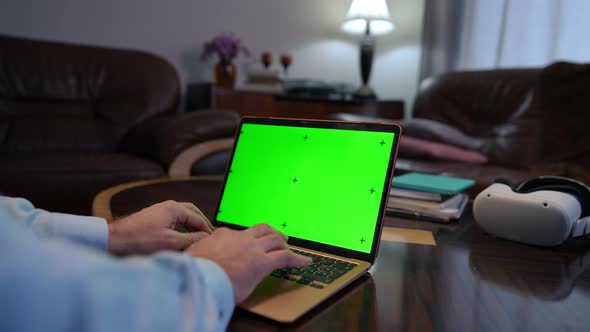 Closeup Green Screen Laptop with Male Hands Typing on Keyboard Indoors alt