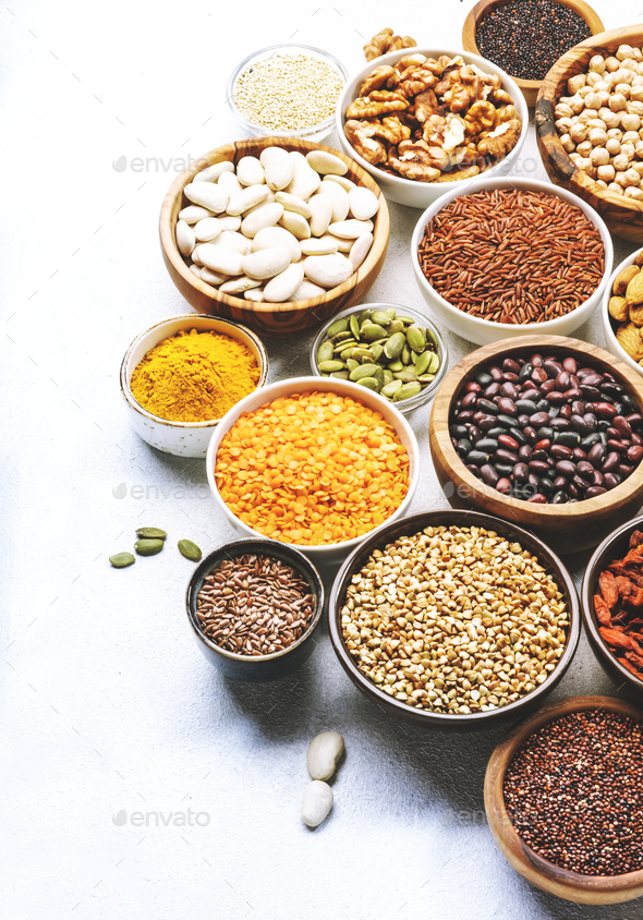 Set of superfoods, legumes, cereals, nuts, seeds in bowls on white