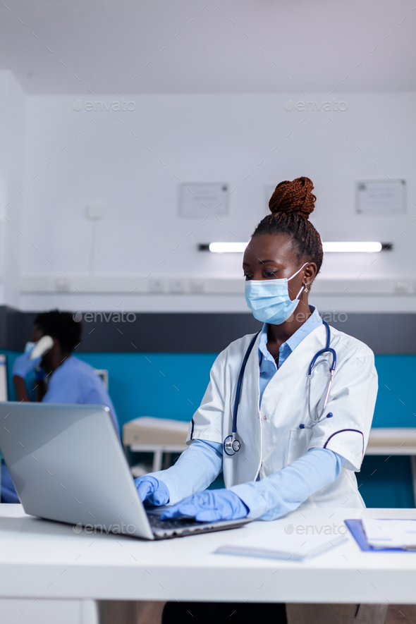 Woman of african ethnicity working as doctor in medical cabinet