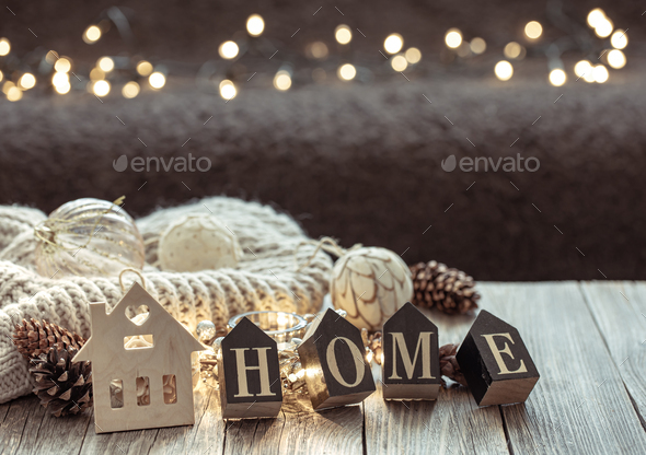 Cozy winter composition with the decorative word home on a blurred  background. Stock Photo by puhimec