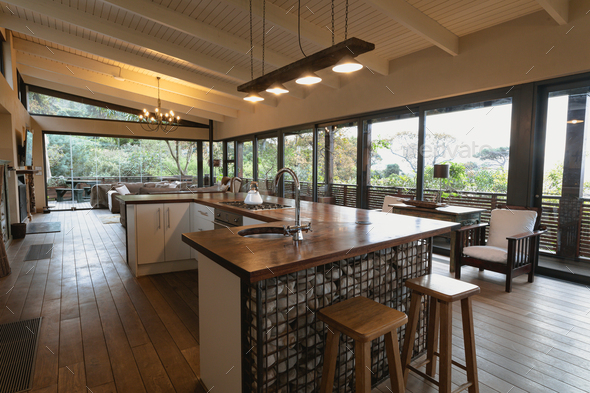 Interior of open plan kitchen diner and living room of comfortable home, with windows to terrace - Stock Photo - Images