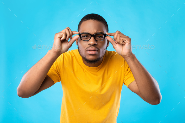 Lækker Retfærdighed menneskelige ressourcer Black Guy In Glasses Squinting Eyes Posing Over Blue Background Stock Photo  by Prostock-studio