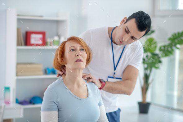 Nice aged woman having a neck massage
