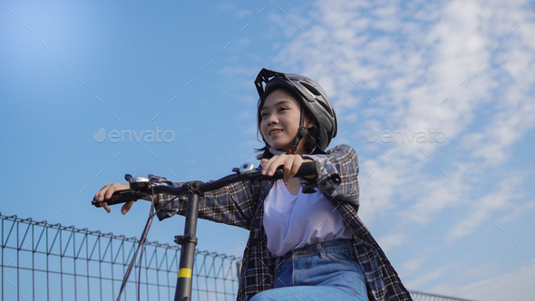 Young Asian woman ride bikes to work she is happy and safe