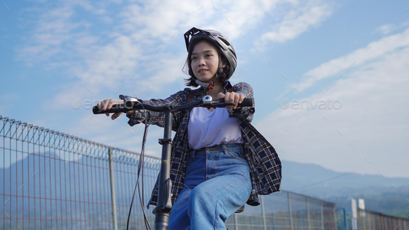 Young Asian woman ride bikes to work she is happy and safe