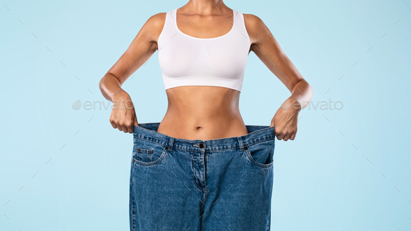 Closeup Of Skinny Woman Pulling Large Loose Jeans