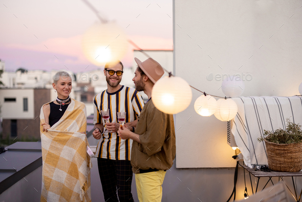Friends have fun on a rooftop party at dusk