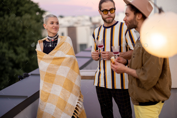 Friends have fun on a rooftop party at dusk