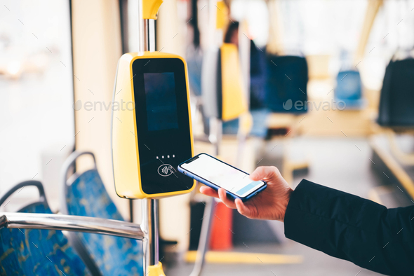 Woman paying conctactless phone for the tram ticket. Payment by card, Bank transfer .