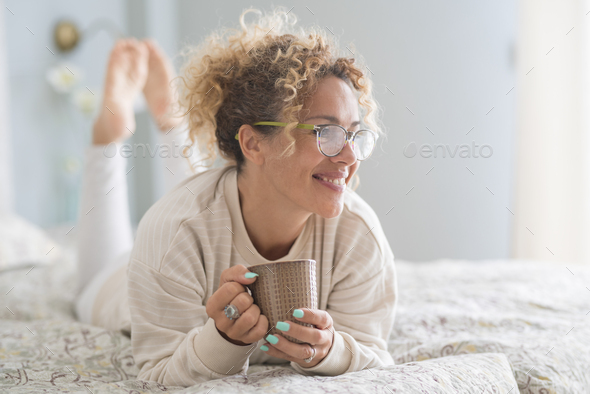 Home lifestyle woman relaxing in the morning on bed in home bedroom. Happy lady lying