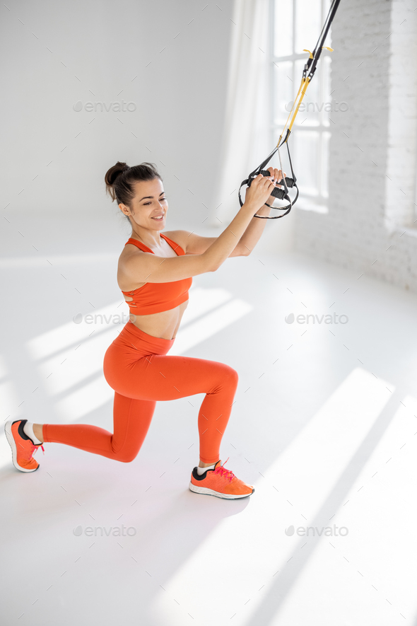Woman training on TRX fitness straps Stock Photo by RossHelen
