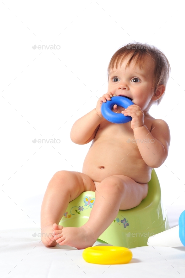 Baby sits on potty and plays toy