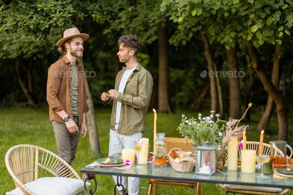 Two male friends talking during a lunch in nature
