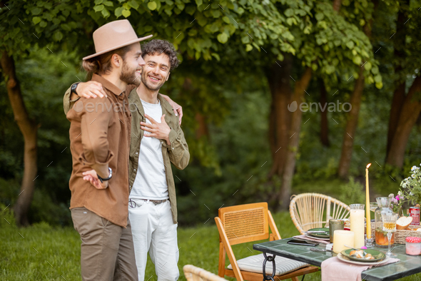 Two male friends talking during a lunch in nature