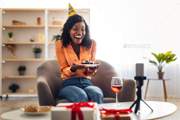 Black Lady Holding Birthday Cake In Front Of Smartphone Indoor