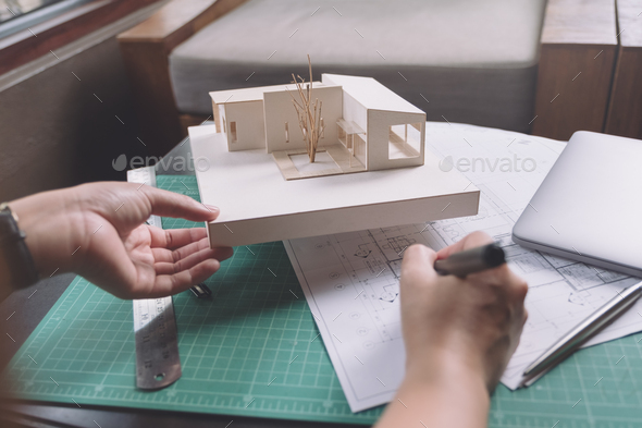 architects drawing shop drawing paper with architecture model on table