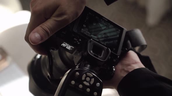 Male Photographer Takes Photographs on a Professional Camera with Flash alt