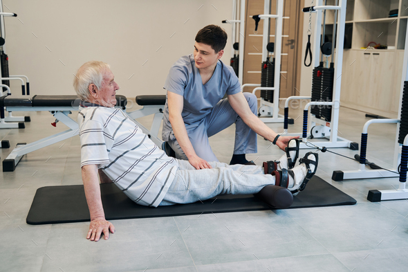 Retiree laying his legs on roller while orthopedist giving instructions