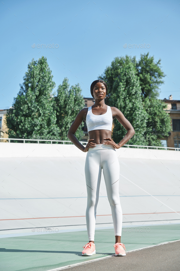 Outdoor full-length fashion portrait of young confident woman