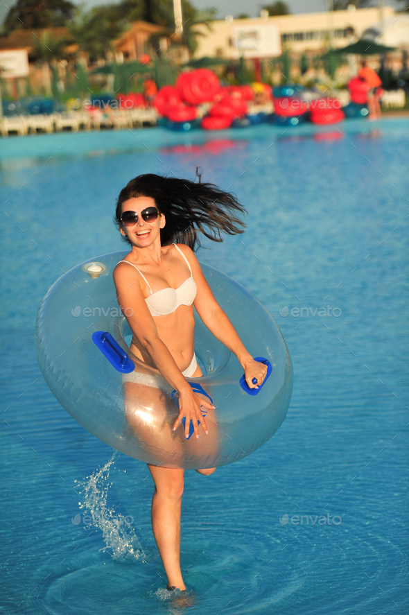 A woman in a white bathing suit with an inflatable circle in a water