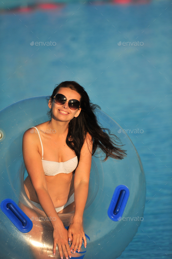 A woman in a white bathing suit with an inflatable circle in a water