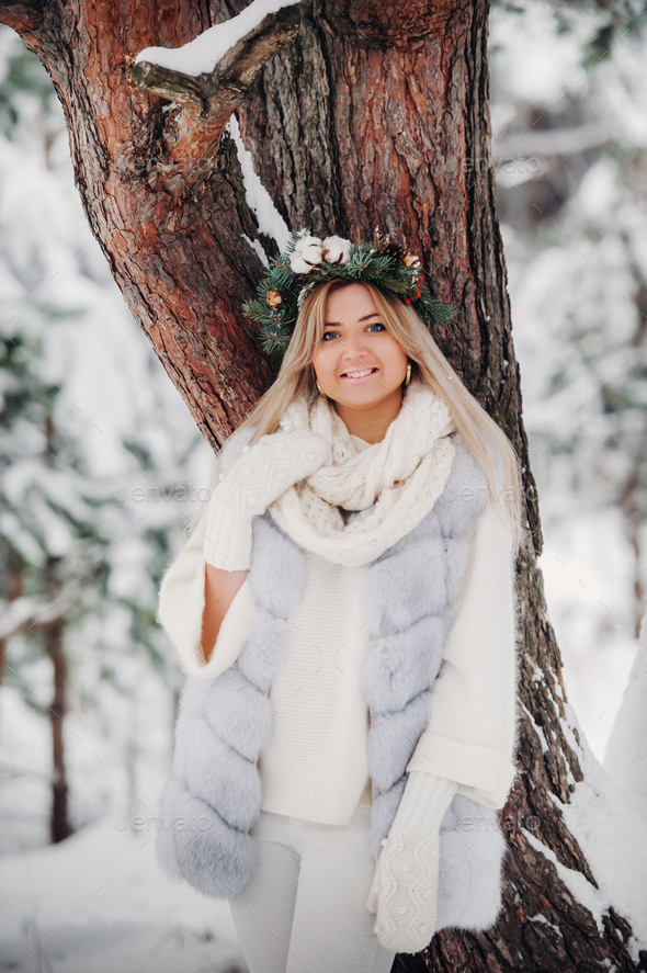 Portrait of a woman in a white fur coat in a cold winter forest. Girl ...