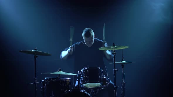 Silhouette Drummer Playing on Drum Kit on Stage in a Dark Studio with Smoke and Neon Lighting alt