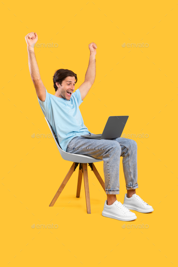 Excited guy using pc celebrating success shaking fists