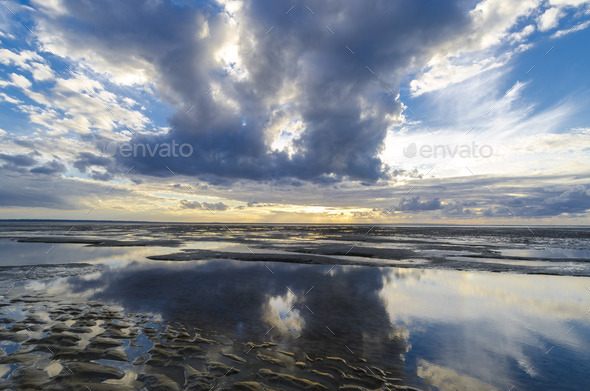 Clouds reflections in the still ocean from the beach, Bay of Saint Michel in Normandy - Stock Photo - Images