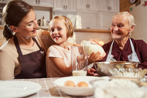 Playful girl sticking out her tongue while pouring milk Stock Photo by ...