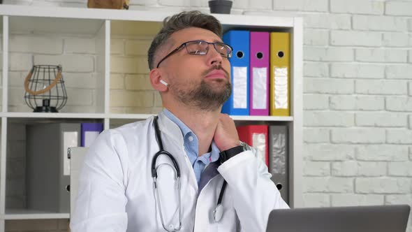 Tired doctor massage neck rubs tense muscles after long time work at laptop alt