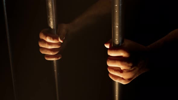 View at prisoner's hands behind bars. Sentenced man. Prison. Jail. Guilty. 4k HD alt