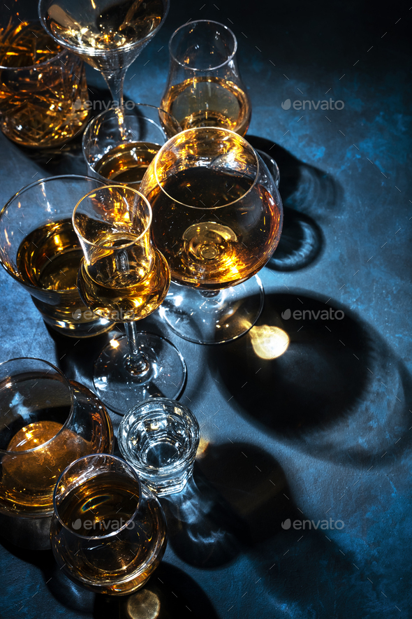 Strong alcohol drinks, hard liquors, spirits and distillates iset in glasses: cognac, scotch