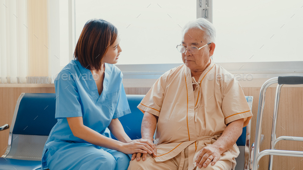 Young Asian woman nurse caregiver encourage take care her senior patient hold hand explain. - Stock Photo - Images