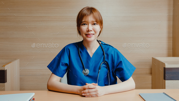 Young lady doctor in white medical uniform with stethoscope using laptop talk video conference call. - Stock Photo - Images