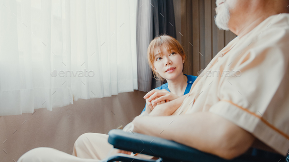 Caring young Asia nurse lady support assist positive old guy patient sit on wheelchair. - Stock Photo - Images