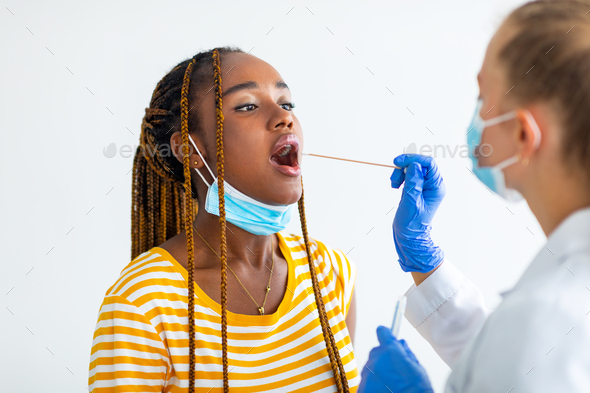 Afro american woman getting oral coronavirus swab test at hospital ...