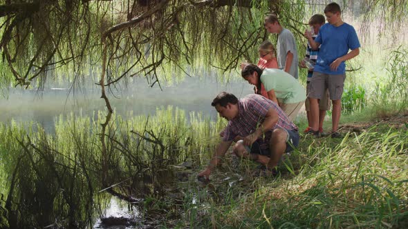 Kids at outdoor school get water samples from pond
